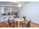 Bright dining area with white table and four brown chairs, hardwood floors and kitchen view at 411 Constance St, Walterboro, SC 29488