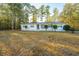 White brick ranch house nestled among tall trees at 411 Constance St, Walterboro, SC 29488