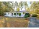 Charming, white-painted home with a well-manicured front yard, mature trees, and an outbuilding on a concrete driveway at 411 Constance St, Walterboro, SC 29488