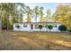 Inviting home featuring a clean, white exterior and tidy front yard landscaping, creating a welcoming curb appeal at 411 Constance St, Walterboro, SC 29488