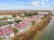 Aerial view of waterfront townhomes with tennis courts and pool at 48 Mariners Cay Dr, Folly Beach, SC 29439