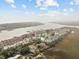 Aerial view showcasing waterfront community, pool, and tennis court at 48 Mariners Cay Dr, Folly Beach, SC 29439
