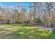 Private backyard with trampoline, mature trees, and a wooden fence at 5039 Thornton Dr, Summerville, SC 29485