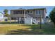 Elevated beach cottage with screened porch, spacious yard, and convenient outdoor shower at 609 Palmetto Blvd, Edisto Beach, SC 29438