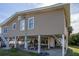 Beach cottage showcasing back elevation, large yard, and outdoor seating at 609 Palmetto Blvd, Edisto Beach, SC 29438