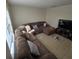 Sunlit living room with sectional sofa, tile floors, and large TV at 6884 Shahid Row, North Charleston, SC 29418