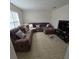 Sunlit living room with sectional sofa, tile floors, and large TV at 6884 Shahid Row, North Charleston, SC 29418
