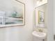 Small powder room with pedestal sink, framed art, and brass light fixture at 729 Opal Wing St, Moncks Corner, SC 29461