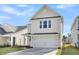 Two-story house with beige siding, white garage door, and landscaping at 733 Opal Wing St, Moncks Corner, SC 29461