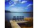 Relaxing lakefront view with wooden dock and rocking chairs at 733 Opal Wing St, Moncks Corner, SC 29461
