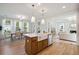 Open concept kitchen with island, white cabinets, and farm sink at 735 Opal Wing St, Moncks Corner, SC 29461