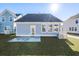 Rear view of charming house, patio, and grassy lawn at 767 Opal Wing St, Moncks Corner, SC 29461