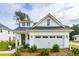 Charming white cottage with gray roof, two-car garage, and landscaped yard at 775 Opal Wing St, Moncks Corner, SC 29461