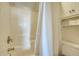 Simple bathroom with shower/tub combo, tile surround, and linen storage at 8934 Sandy Creek Rd, Edisto Island, SC 29438