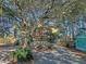 Two story home with red accents, surrounded by lush trees and landscaping at 8934 Sandy Creek Rd, Edisto Island, SC 29438