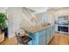 Open kitchen with a teal island and stainless steel appliances at 8934 Sandy Creek Rd, Edisto Island, SC 29438