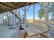 Wooden picnic table on a screened-in patio at 8934 Sandy Creek Rd, Edisto Island, SC 29438