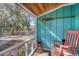 Screened porch with rocking chair and view of trees at 8934 Sandy Creek Rd, Edisto Island, SC 29438