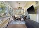 Screened porch with wicker furniture and a large TV at 8934 Sandy Creek Rd, Edisto Island, SC 29438