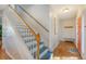Elegant staircase with wooden handrail and blue painted steps at 8934 Sandy Creek Rd, Edisto Island, SC 29438