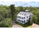White two-story house with wrap-around porch, surrounded by lush greenery at 124 Mary St, Mount Pleasant, SC 29464