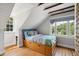 Bright bedroom with wood floors, built-in drawers, and sloped ceilings at 124 Mary St, Mount Pleasant, SC 29464