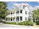 Charming two-story white house with large front porch and lush landscaping at 124 Mary St, Mount Pleasant, SC 29464