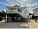 Elevated beach house with wrap around porch and stairs at 1306 Palmetto Blvd, Edisto Beach, SC 29438