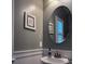 Updated powder room features a pedestal sink, round mirror, and decorative wall art at 1504 Oldenburg Dr, Mount Pleasant, SC 29466