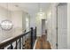 Elegant upstairs hallway with chandelier, hardwood floors, and access to bedrooms at 1504 Oldenburg Dr, Mount Pleasant, SC 29466