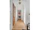 Long hallway with white shiplap walls, hardwood floors, and wooden doors at 2618 Raven Dr, Sullivans Island, SC 29482