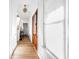 Light-filled hallway with hardwood floors, white walls, and wooden doors at 2618 Raven Dr, Sullivans Island, SC 29482