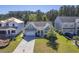 Aerial view of a charming light green house with a gray roof and a two-car garage, situated in a well-maintained neighborhood at 311 Calm Water Way, Summerville, SC 29486