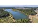 Aerial view of a serene community lake surrounded by lush green trees and a residential area at 311 Calm Water Way, Summerville, SC 29486