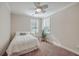 Bedroom with a queen bed, plant, and two windows at 311 Calm Water Way, Summerville, SC 29486