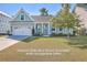 Charming light teal house with a white door and attached garage at 311 Calm Water Way, Summerville, SC 29486