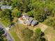 Stunning aerial view of a modern farmhouse with a well-manicured lawn and circular driveway at 3324 Westphal Dr, Johns Island, SC 29455