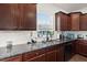 Kitchen with dark wood cabinets, granite counters, and double sink at 346 Bradley Bend Drive, Moncks Corner, SC 29461