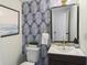Stylish powder room with palm leaf wallpaper and gold fixtures at 519 Parkdale Dr # J, Charleston, SC 29414