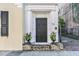 Dark wood front door with sidelights, flanked by planters, and a brick stoop at 53 Hasell Street St # H, Charleston, SC 29401