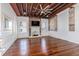 Spacious living room with hardwood floors, exposed beams, fireplace, and a TV at 53 Hasell Street St # H, Charleston, SC 29401