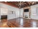 Living room with hardwood floors, exposed beams, fireplace, and kitchen peek at 53 Hasell Street St # H, Charleston, SC 29401