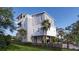 Attractive beach house with multi-story balconies, set in a beautifully landscaped yard with tropical trees at 615 W Beach Ct, Folly Beach, SC 29439