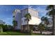 Beautiful coastal home featuring elevated construction, a charming fence, and lush tropical landscaping at 615 W Beach Ct, Folly Beach, SC 29439