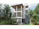 Elevated home with light blue siding, multiple balconies, and tropical landscaping at 615 W Beach Ct, Folly Beach, SC 29439