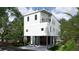 Modern coastal home on stilts with light blue siding and garage at 615 W Beach Ct, Folly Beach, SC 29439