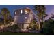 Elegant raised beach house at twilight with a convenient golf cart parking area beneath the main structure at 615 W Beach Ct, Folly Beach, SC 29439