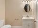 Small bathroom with toilet, vanity, and oval mirror at 8604 Fox Hollow Rd, North Charleston, SC 29420