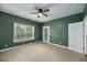 Simple bedroom with green walls, ceiling fan, and neutral carpet at 8604 Fox Hollow Rd, North Charleston, SC 29420