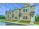 Tan three-unit townhome building with white doors and landscaping at 1001 Twin Rivers Dr # 65, Wando, SC 29492